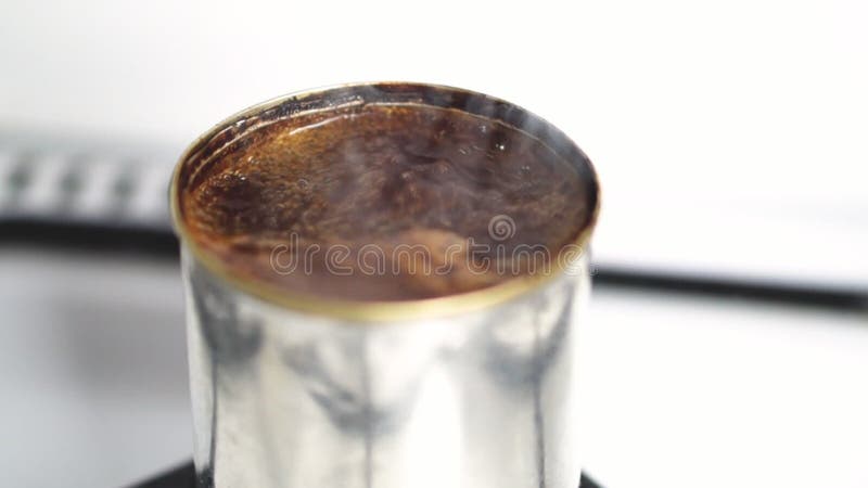 Video di chiusura del caffè naturale con punto di ebollizione in una capsula di metallo sopra il bruciatore di una stufa a gas di archivi video