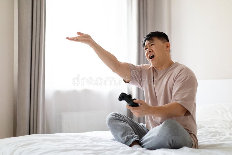 Asian man fun playing video games console with his girlfriend