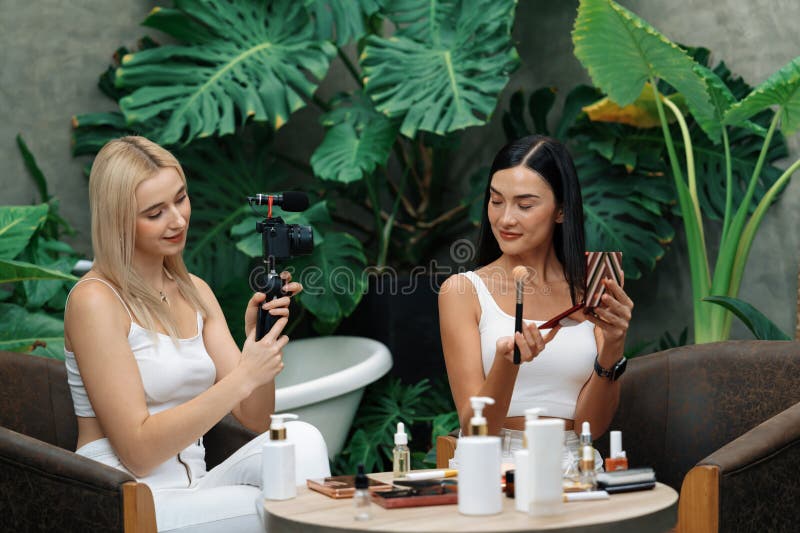 Two  content creator making natural  and cosmetic tutorial on green plant garden video.  blogger showing how to  care to social medial audience using selfie stick . Blithe. Two  content creator making natural  and cosmetic tutorial on green plant garden video.  blogger showing how to  care to social medial audience using selfie stick . Blithe