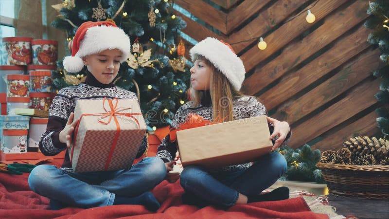 Video in 4k dove i bambini vestiti da santa si prendono in giro tra di loro, competendo il cui presente è migliore