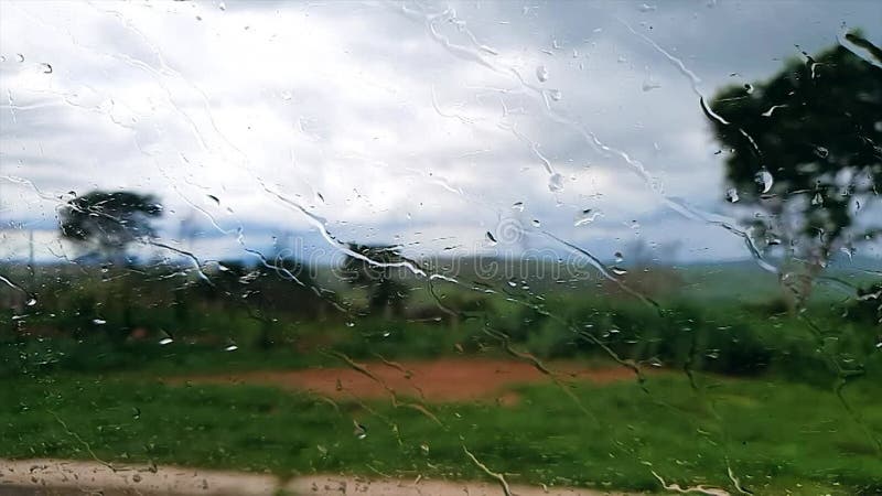 Video in slow motion di gocce d'acqua piovana che scorrono lungo il vetro dell'auto