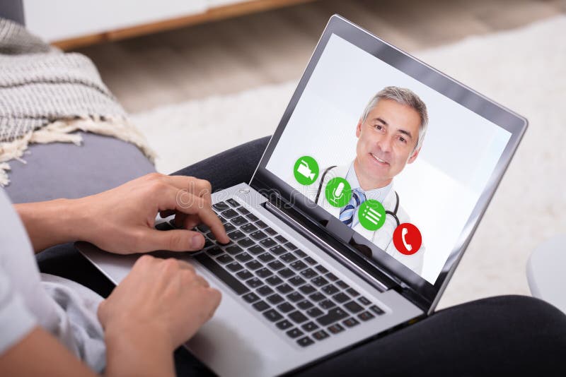 Videoconfer?ncia do homem com doutor On Laptop imagens de stock royalty free Videoconfer?ncia do homem com doutor On Laptop imagens de stock royalty free