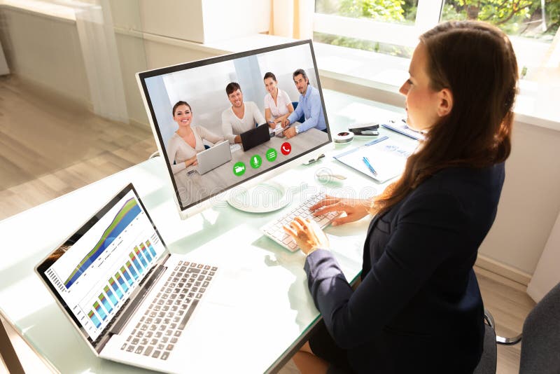 Videoconferencing коммерсантки с ее коллегами на компьютере стоковые изображения rf Videoconferencing коммерсантки с ее коллегами на компьютере стоковые изображения rf