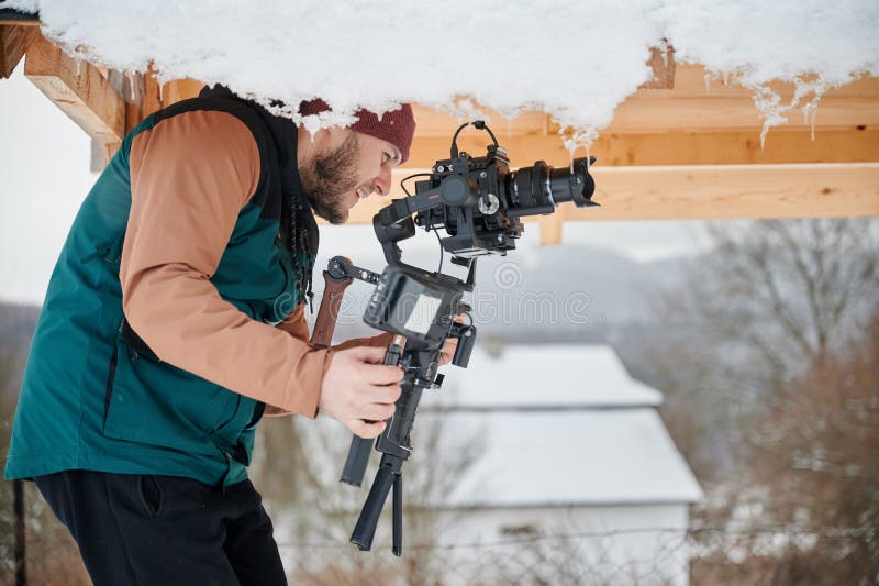 Videographer Man with Camera Mounted on Gimbal Stabilizer Equipment in