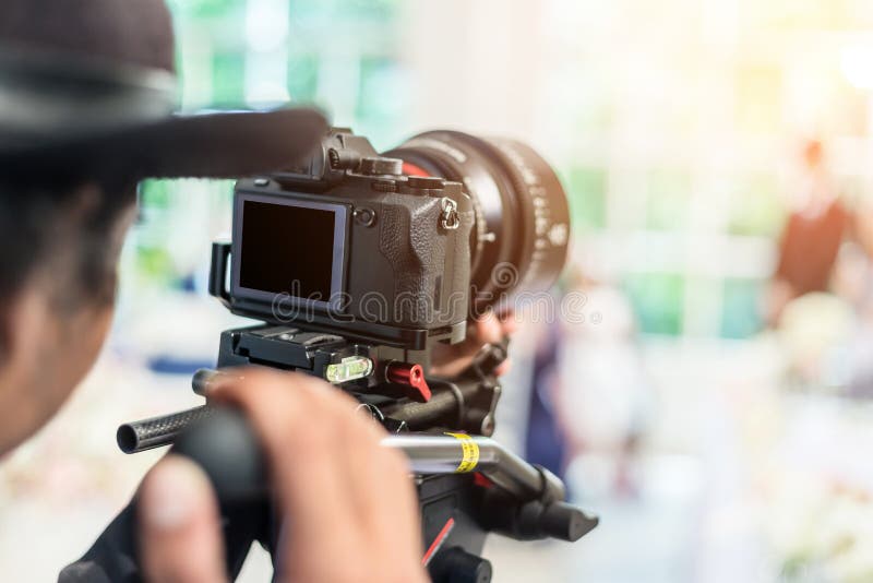 Videographer takes video camera with blank screen royalty free stock photography