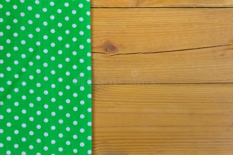 Empty wooden deck table with green tablecloth with polka dots. Background. Empty wooden deck table with green tablecloth with polka dots. Background