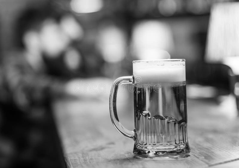 Vidrio con la cerveza en el contador de la barra, tabla, visitante en el fondo, defocused Vidrio con la cerveza de barril fresca foto de archivo Vidrio con la cerveza en el contador de la barra, tabla, visitante en el fondo, defocused Vidrio con la cerveza de barril fresca foto de archivo