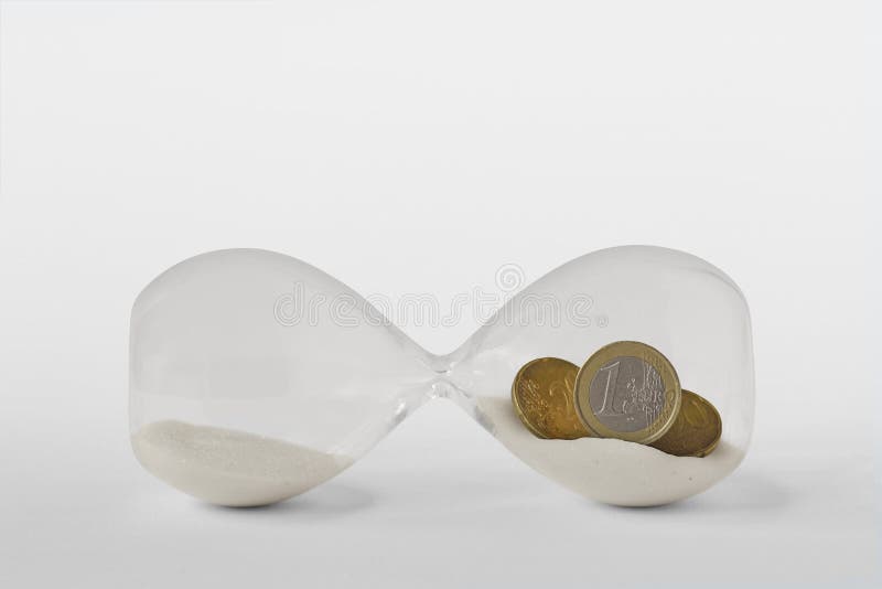 Vidrio con monedas en euros sobre fondo blanco - Concepto de economía y tiempo de parada foto de archivo