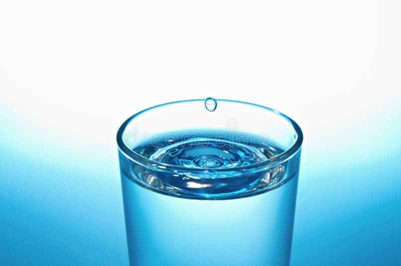 Vidrio de agua con gota imagen de archivo libre de regalías Vidrio de agua con gota imagen de archivo libre de regalías