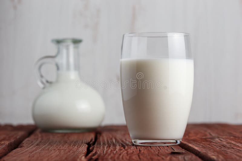 Vidrio de leche que se coloca en la tabla vieja fotos de archivo libres de regalías Vidrio de leche que se coloca en la tabla vieja fotos de archivo libres de regalías