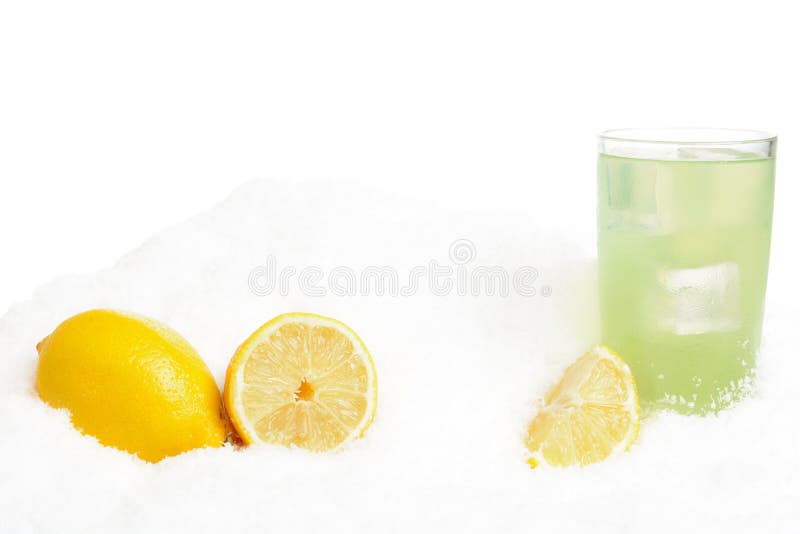 Vidrio de zumo de lima con los cubos de hielo, limones en nieve en blanco imagen de archivo libre de regalías Vidrio de zumo de lima con los cubos de hielo, limones en nieve en blanco imagen de archivo libre de regalías
