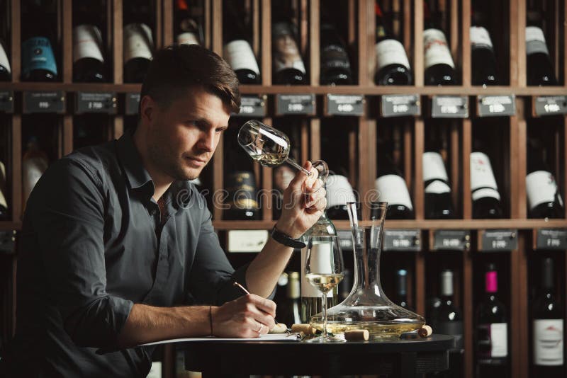 Vidrio degustating del vino blanco del Sommelier vertido imagenes de archivo Vidrio degustating del vino blanco del Sommelier vertido imagenes de archivo