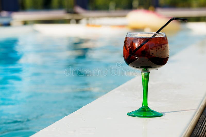 Vidrio del cóctel delicioso por la piscina en verano fotos de archivo libres de regalías Vidrio del cóctel delicioso por la piscina en verano fotos de archivo libres de regalías