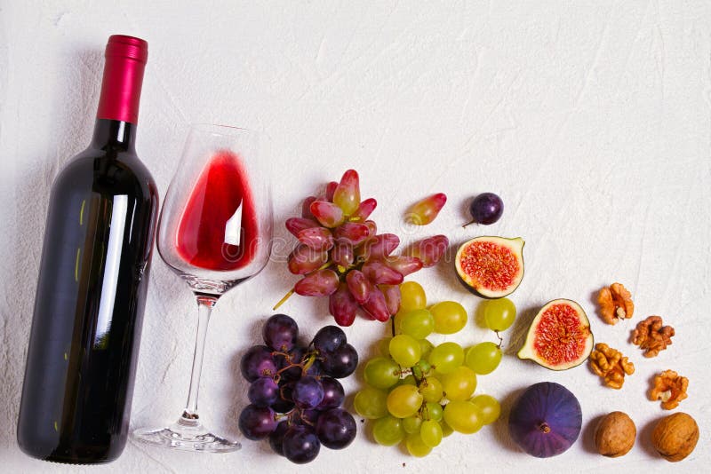 Vidrio y botella de vino con las frutas y las nueces en el fondo blanco Todavía del vino vida foto de archivo Vidrio y botella de vino con las frutas y las nueces en el fondo blanco Todavía del vino vida foto de archivo