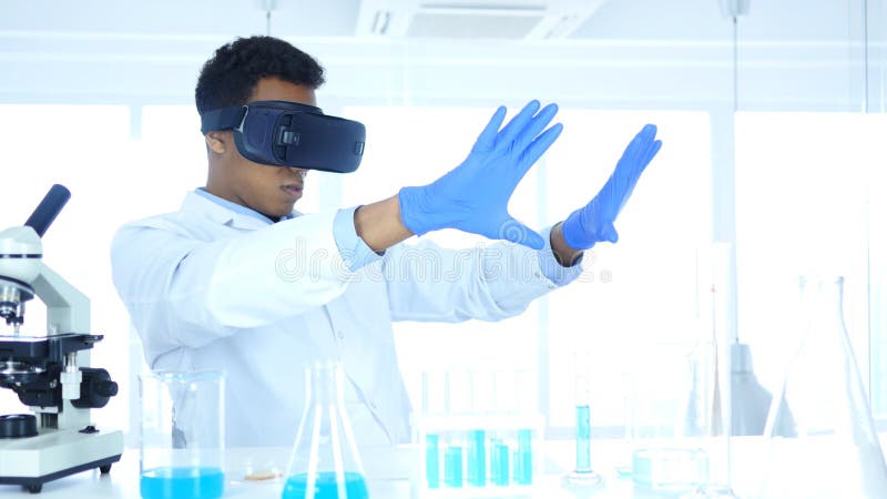 Vidrios de la realidad virtual de Using del científico para la investigación y la imaginación en el laboratorio, gafas de Vr foto de archivo libre de regalías Vidrios de la realidad virtual de Using del científico para la investigación y la imaginación en el laboratorio, gafas de Vr foto de archivo libre de regalías