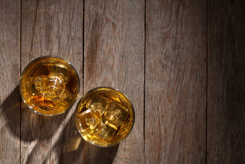 Vidrios de whisky con hielo en la madera imagen de archivo libre de regalías Vidrios de whisky con hielo en la madera imagen de archivo libre de regalías