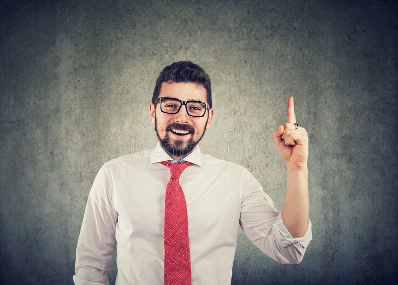 Vidrios que llevan del hombre de negocios con una buena idea que señala con su finger para arriba y la sonrisa imagen de archivo libre de regalías Vidrios que llevan del hombre de negocios con una buena idea que señala con su finger para arriba y la sonrisa imagen de archivo libre de regalías