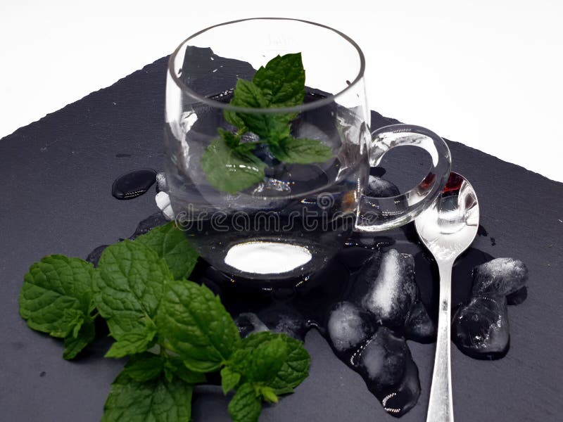 Vidro com água e a hortelã fresca no gelo fotos de stock royalty free