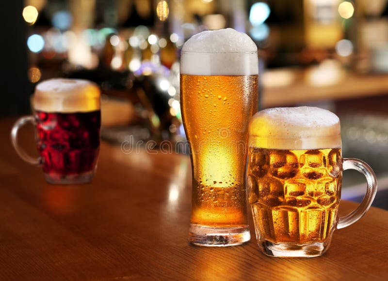 Glass of light beer on a dark pub. Glass of light beer on a dark pub.