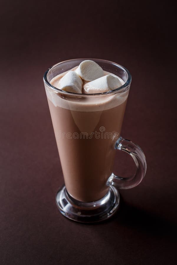 Vidro do cacau com os três marshmallows no CCB marrom escuro elegante imagens de stock royalty free Vidro do cacau com os três marshmallows no CCB marrom escuro elegante imagens de stock royalty free