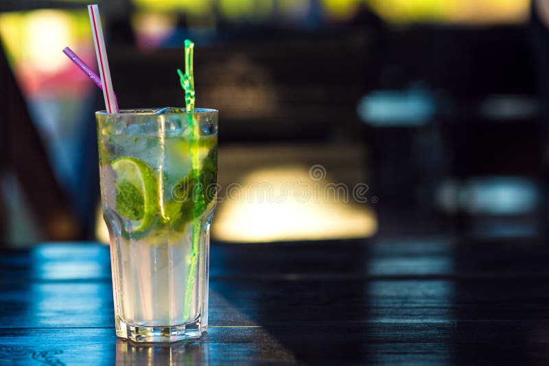 Vidro do cocktail do mojito com sraws bebendo na tabela de madeira fotos de stock royalty free Vidro do cocktail do mojito com sraws bebendo na tabela de madeira fotos de stock royalty free