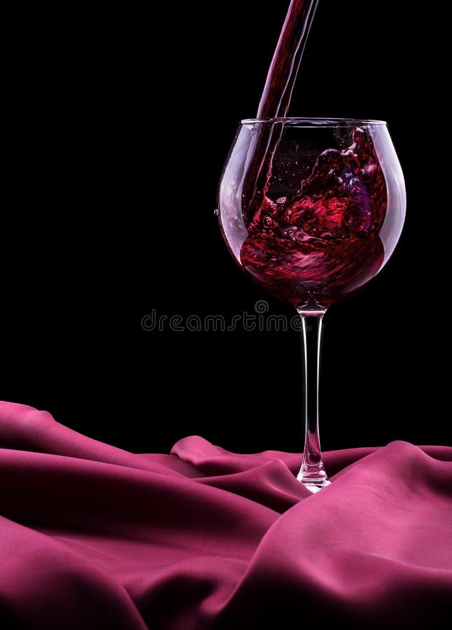 Vidro do vinho na seda vermelha