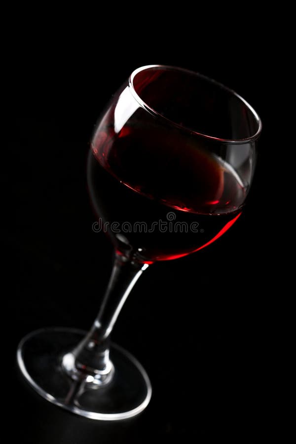 Vidro do vinho vermelho sobre o preto