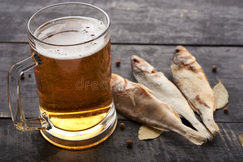 Vidro secado dos peixes e de cerveja em uma tabela de madeira em um bar imagem de stock royalty free Vidro secado dos peixes e de cerveja em uma tabela de madeira em um bar imagem de stock royalty free