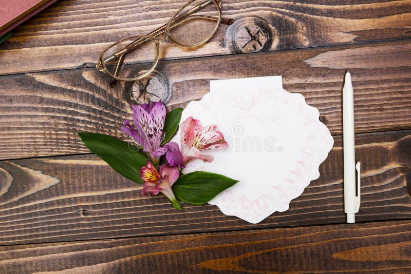 Vidros, caderno e flores no fundo de madeira foto de stock Vidros, caderno e flores no fundo de madeira foto de stock