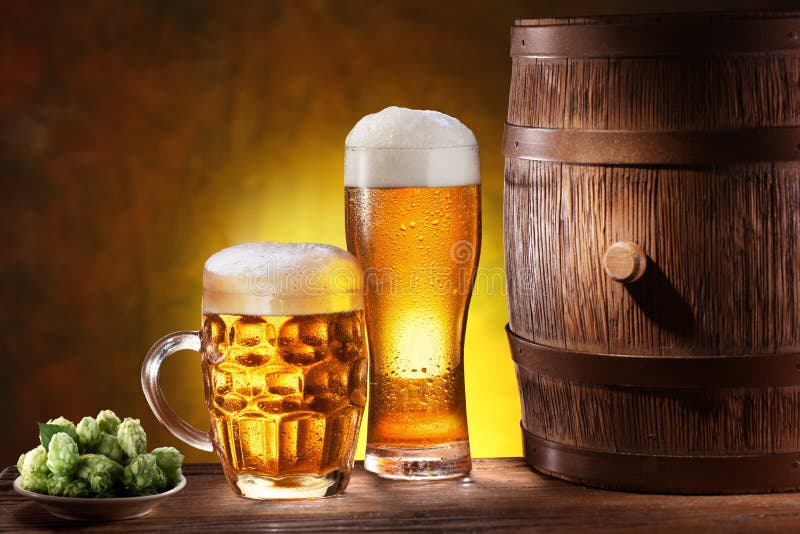 Beer glasses with a wooden barrel. Background - dark yellow gradient. Beer glasses with a wooden barrel. Background - dark yellow gradient.