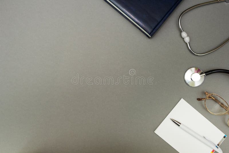 Vidros, estetoscópio e um caderno em um fundo cinzento, conceito imagens de stock royalty free Vidros, estetoscópio e um caderno em um fundo cinzento, conceito imagens de stock royalty free