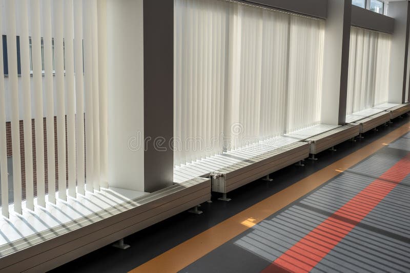 Vidros grandes com persianas verticais num edifício moderno