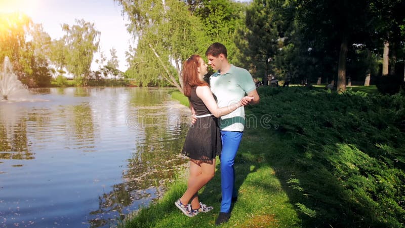 Vidéo animée lente de beaux jeunes couples étreignant sur la rive