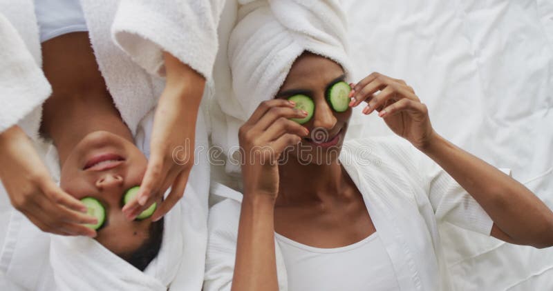 Vidéo d'amies féminines en robes joyeuses et diverses s'amusant avec des tranches de concombre banque de vidéos