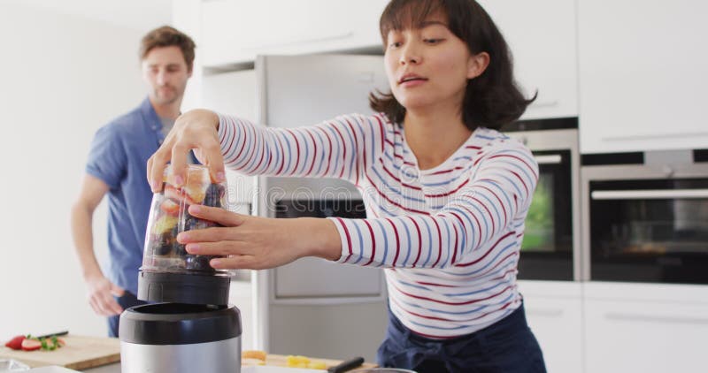 Vidéo d'un couple heureux et diversifié préparant du jus clips vidéos