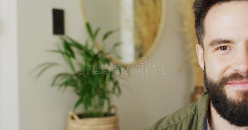Vidéo demi-visage portrait d'un caucasien barbu souriant se reposant à la maison avec espace copie clips vidéos