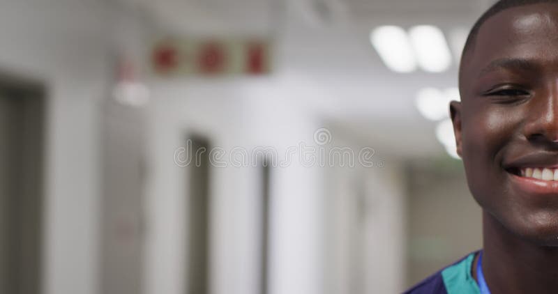 Vidéo demi-visage portrait d'un travailleur médical africain américain souriant dans un couloir espace copie banque de vidéos