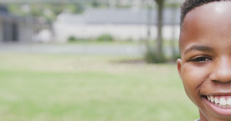 Vidéo demi-visage portrait d'un écolier afro-américain souriant sur le terrain avec espace copie clips vidéos