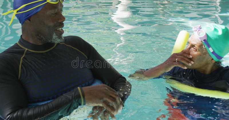 Vidéo verticale d'un couple africain senior américain heureux faisant de l'exercice dans la piscine banque de vidéos