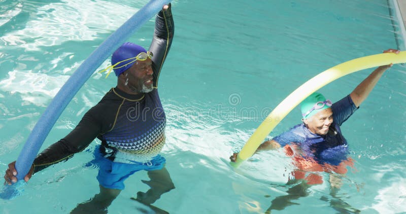 Vidéo d'un couple africain senior américain heureux faisant de l'exercice dans la piscine clips vidéos