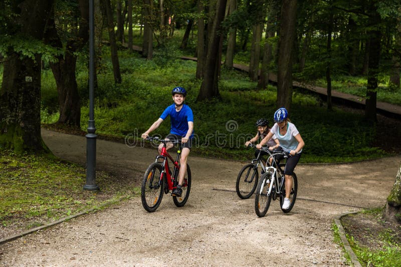 Vie saine - Des gens heureux qui font du vélo dans le parc de la ville photos libres de droits Vie saine - Des gens heureux qui font du vélo dans le parc de la ville photos libres de droits