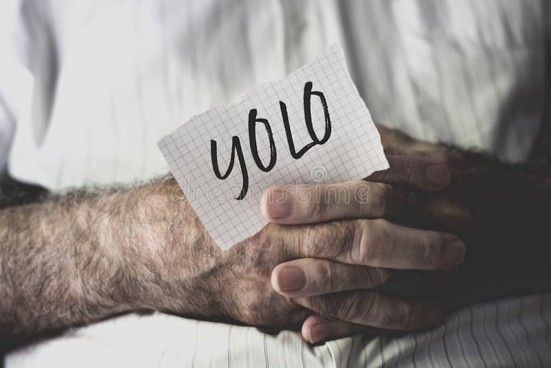 Vieil homme avec une note avec le mot yolo image libre de droits Vieil homme avec une note avec le mot yolo image libre de droits