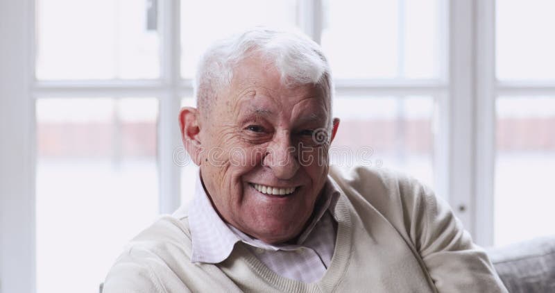 Vieil homme heureux avec les dents blanches saines à regarder la caméra.