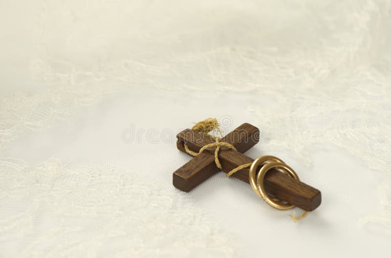 Vieille croix en bois avec les anneaux d'or sur la dentelle blanche image stock Vieille croix en bois avec les anneaux d'or sur la dentelle blanche image stock