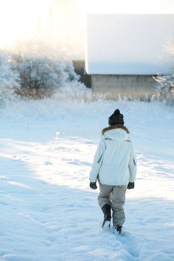 Vieille femme agée dans des vêtements chauds marchant à la maison par la chute de neige importante un matin froid d'hiver au leve photos stock Vieille femme agée dans des vêtements chauds marchant à la maison par la chute de neige importante un matin froid d'hiver au leve photos stock