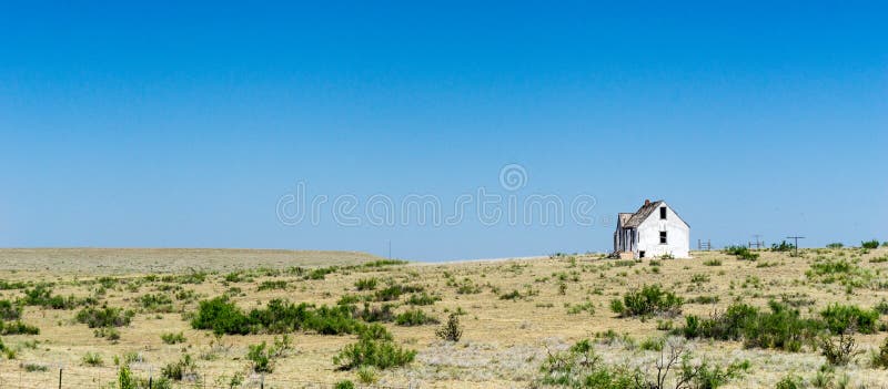 Vieille maison en bois blanche délabrée et abandonnée sur la prairie à distance dans le middlew de nulle part sous un ciel bleu images libres de droits Vieille maison en bois blanche délabrée et abandonnée sur la prairie à distance dans le middlew de nulle part sous un ciel bleu images libres de droits