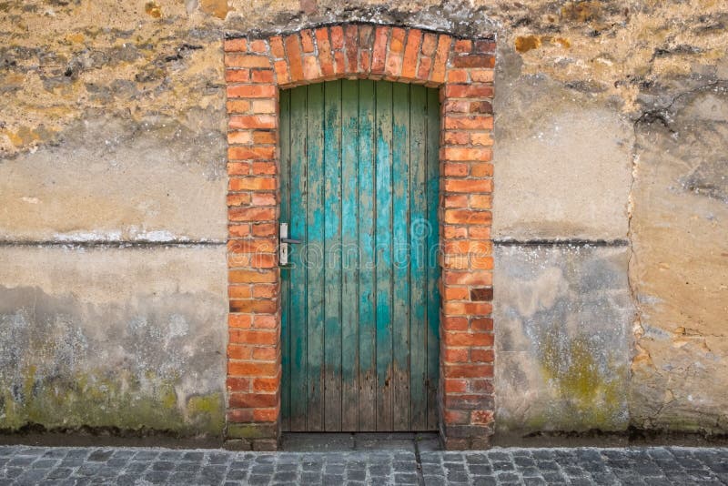 Old green or turquoise wood door with a red brick arch in Echternach, Luxembourg. Old green or turquoise wood door with a red brick arch in Echternach, Luxembourg.