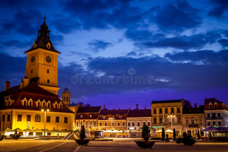 Brasov old town, Transylvania, Romania, with The Council Square and other historic buildings with medieval architecture. Romanian old architecture in the city of Brasov, at nights with city lights. Brasov old town, Transylvania, Romania, with The Council Square and other historic buildings with medieval architecture. Romanian old architecture in the city of Brasov, at nights with city lights