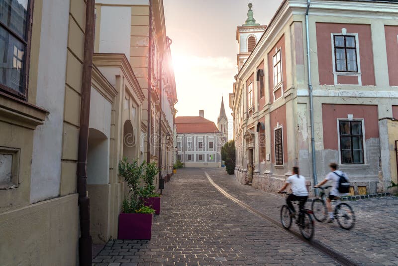 Vieille ville de la célèbre ville hongroise Veszprem avec des motos floues au coucher du soleil images stock Vieille ville de la célèbre ville hongroise Veszprem avec des motos floues au coucher du soleil images stock