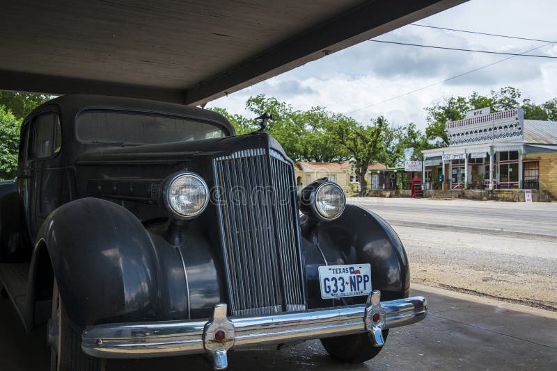 Vieille voiture avec l'épicerie générale et bureau de poste sur le fond dans la petite ville de Hye dans le Texas, Etats-Unis photos stock Vieille voiture avec l'épicerie générale et bureau de poste sur le fond dans la petite ville de Hye dans le Texas, Etats-Unis photos stock